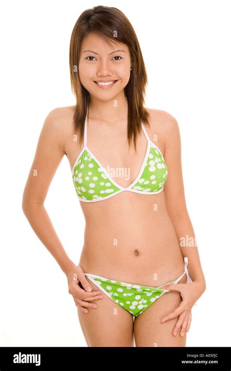 Eine hübsche junge Asiatin in einem grünen Polkadot bikini Stockfoto