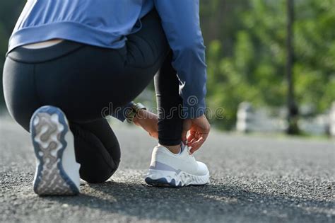 Cropped Image Of Female Runner Tying Shoelaces Getting Ready For