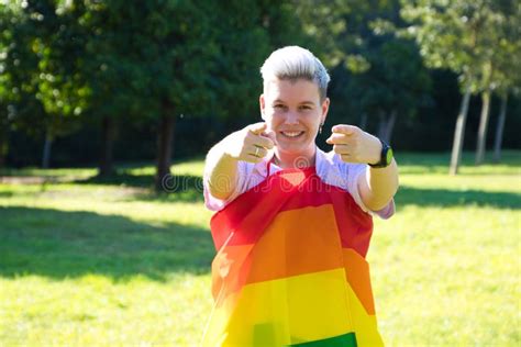 Gender Non Binary Person Is Rolled Up With The Gay Pride Flag On His Body She Is Looking At The