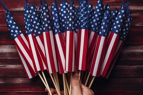 Premium Photo Mans Hand Holding Usa Flags In Hand Against Colored