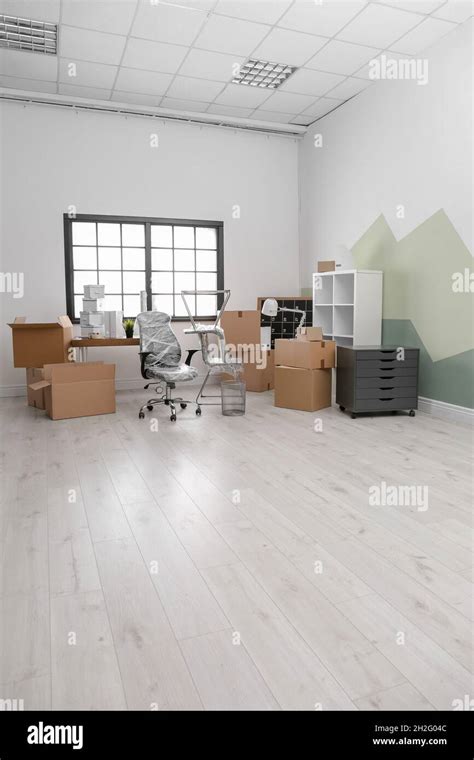 Moving boxes and furniture in new office Stock Photo - Alamy