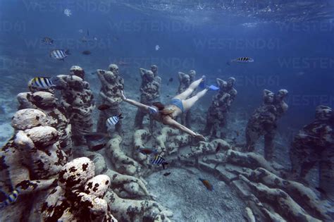 Woman Swimming Near Underwater Sculpture Made By Jason Decaires Taylor