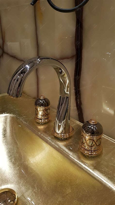 Хромированный кран-смеситель с декорированными вентилями в дизайне санузла