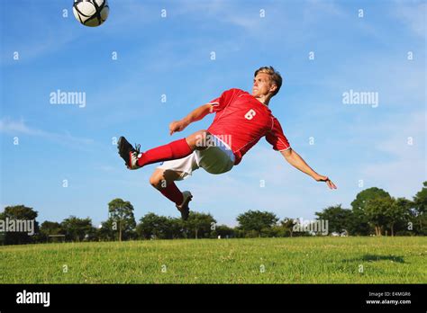 Soccer Player Kicking The Ball In Mid Air Stock Photo Alamy