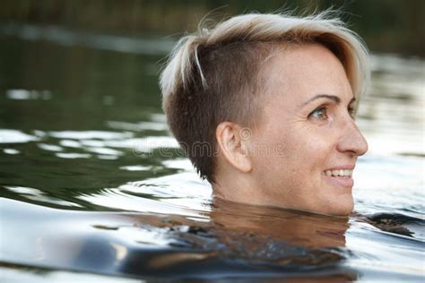 Close Up Of A Woman Blonde Middle Aged Nude Swims In The River Selective Focus Stock Photo