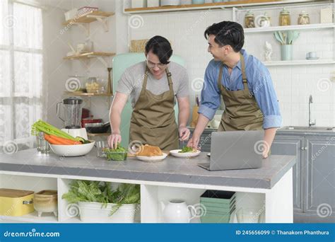 Jovem Casal Gay Sorrindo Cozinhando Na Cozinha Em Casa Lgbtq E Conceito De Diversidade Imagem De