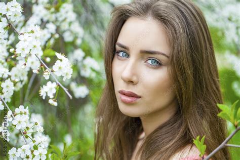 Portrait of beautiful young brunette woman in spring blossom Stock 写真 Adobe Stock