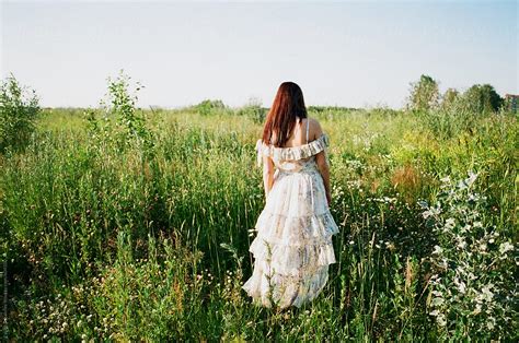 «beautiful Woman Walking Away In High Grass Del Colaborador De Stocksy