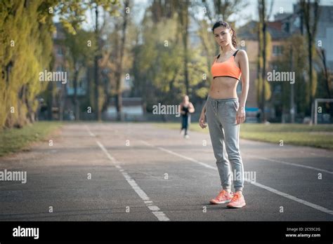 Attractive Brunette Woman Warm Up And Stretching In Park At Sunshine Stock Photo Alamy