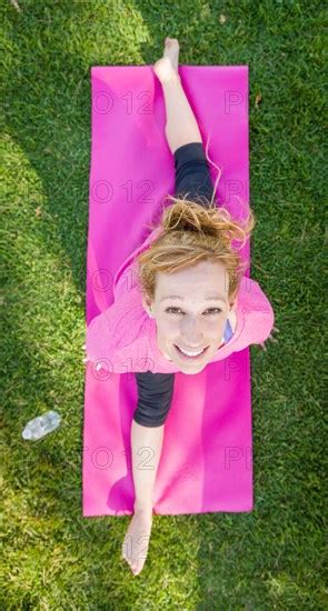 Overhead Of Young Fit Flexible Adult Woman Outdoors On The Grass With