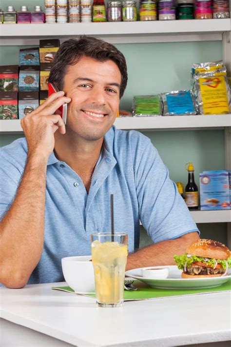 Homem Que Usa O Telefone Celular Na Tabela No Supermercado Foto De