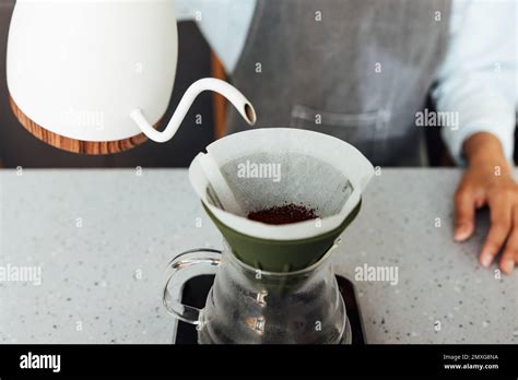 Primer plano de un barista irreconocible que prepara café con un filtro