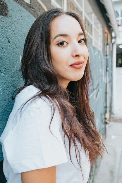 Premium Photo Portrait Of Young Woman Standing Against Wall