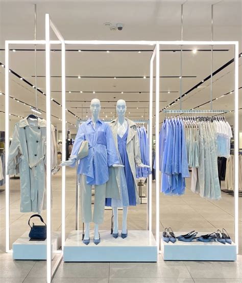 Two Mannequins Dressed In Blue And White Are Standing Next To Each Other