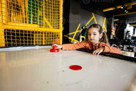 Cute preschooler girl playing air hockey at kids play center. 24603166 ...