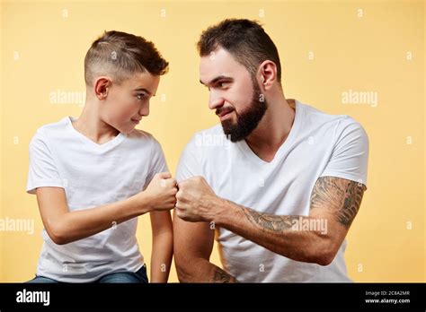 Smiling Father And Son With Pleasant Smile Give Fist Bump To Each Other