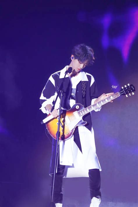 A Person With A Guitar On Stage