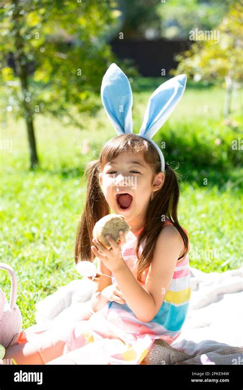 Girl Trying To Eat Easter Hot Cross Bun Stock Photo Alamy