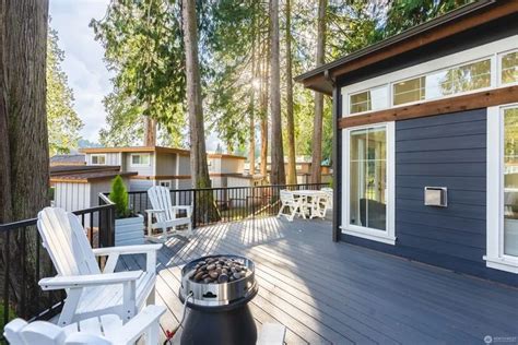 A Deck With Chairs And An Outside Fire Pit On The Side Of It