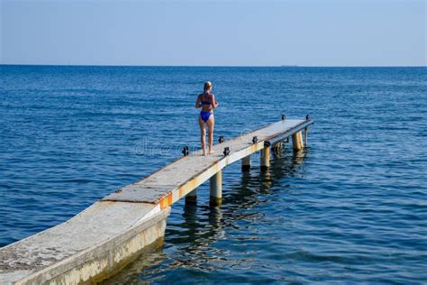 Una Bella Ragazza In Un Bikini Blu Cammina Il Pilastro Al Mare Pilastro