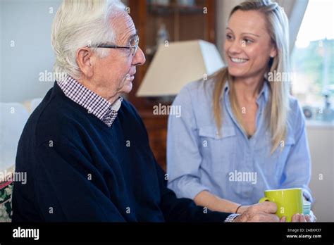 Grandfather Having Hot Drink And Talking With Adult Granddaughter At Home Stock Photo Alamy