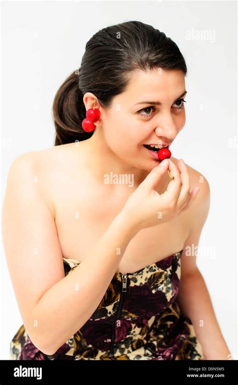 A Nice Brunette Girl Tasting Some Cherries Stock Photo Alamy