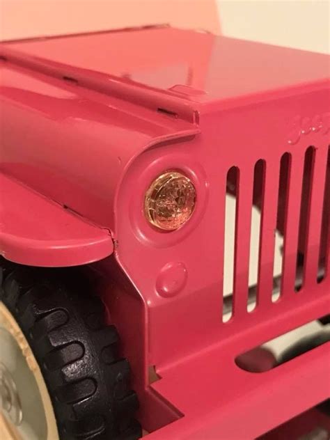 A Pink Toy Jeep With Wheels And Tires