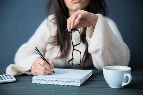 Bloc De Notas De Mano De Mujer Con Gafas Foto Premium