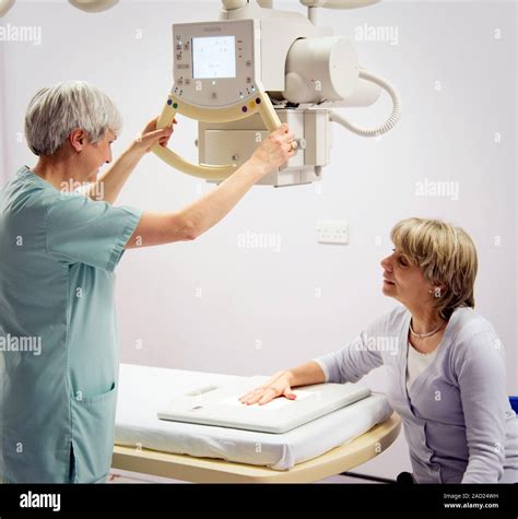 Radiographer preparing a hand X-ray. Hospital radiographer positioning