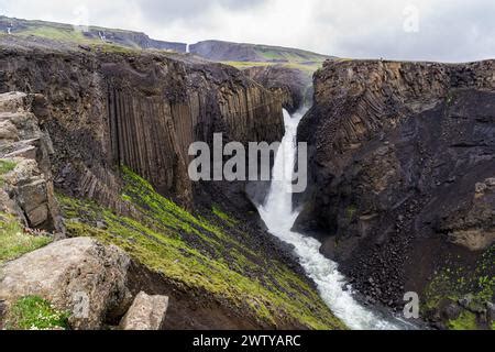 Beautiful and tall Icelandic waterfall Hengifoss and hiking trail to it, Iceland, sunny day ...