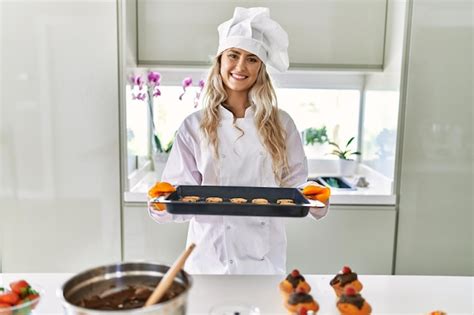 Jeune Femme Portant Un Uniforme De Cuisinier Tenant Un Plateau De Four