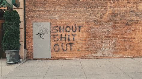 "A City Sidewalk With Profanity Graffiti On A Brick Wall" by Stocksy Contributor "Greg Schmigel ...