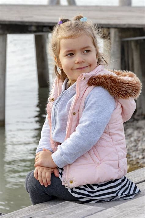 Portrait D Une Fille Blonde Heureuse Sur Fond De Pieux En Bois D Un Poste D Amarrage Maritime