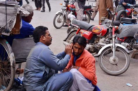 فیصل آباد ایک شہری اتائی سے اپنے کان کا علاج کروا رہا ہے۔