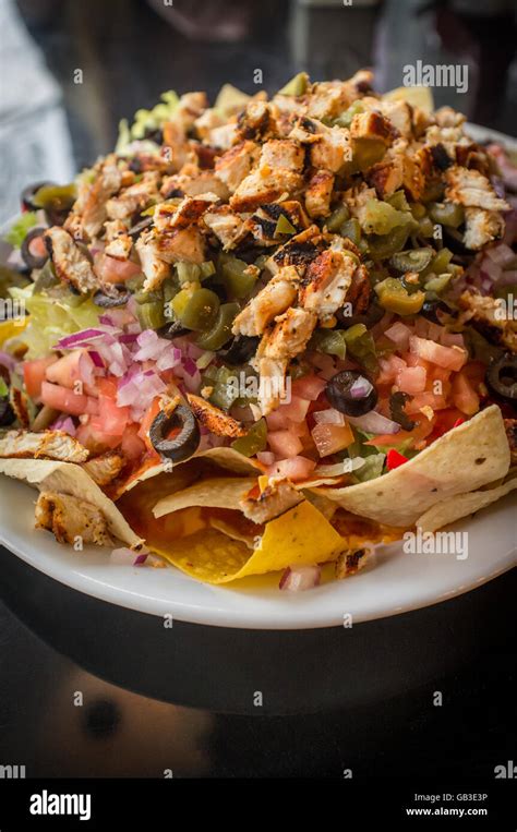 Colorful Mexican nachos with chicken black olives melted cheese ...