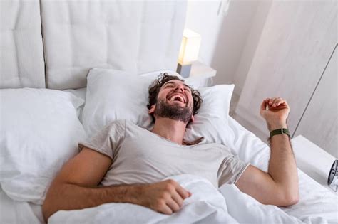 Premium Photo Young Man Sleeping Waking Up And Stretching In His Bed