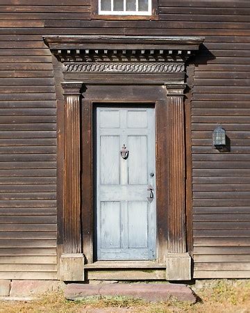 An Old Wooden Building With A White Door