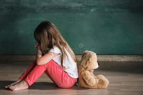 Petite Fille Avec L Ours De Nounours Se Reposant Sur Le Plancher Dans