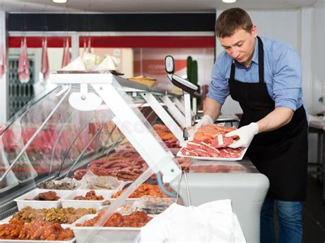 Butcher Arranging Meat Products in Display Case Stock Image - Image of ...