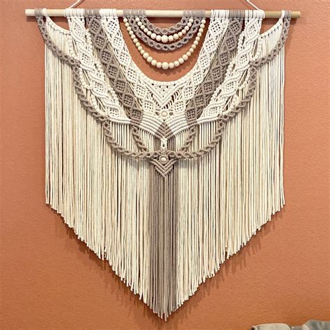 A Wall Hanging With Beads And Tassels On It