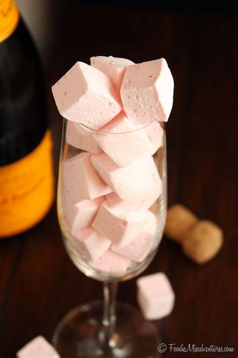 A Glass Filled With Marshmallows Next To A Bottle