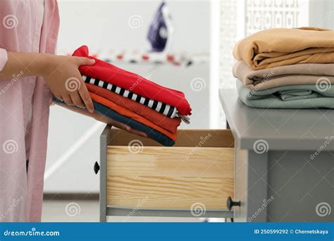 Woman Putting Clean Clothes Into Drawer At Home Closeup Stock Photo