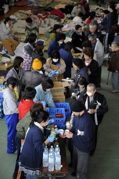 避難所で食べ物や水を受け取る被災者（岩手県：東日本大震災 避難所 写真特集：時事ドットコム