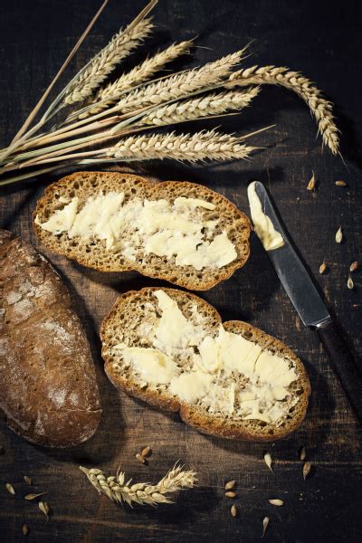 Butterbrot Und Weizenohr Auf Dunklem Holz Lizenzfreies Bild