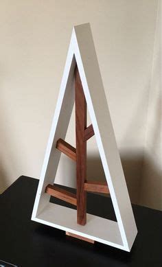 A White And Brown Triangle Shaped Sculpture Sitting On Top Of A Black