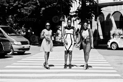 tres elegantes mujeres afroamericanas caminando en el cruce de peatones