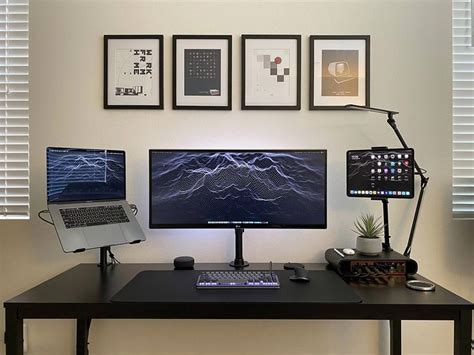 A Computer Desk With Two Monitors And A Laptop On It In Front Of Some