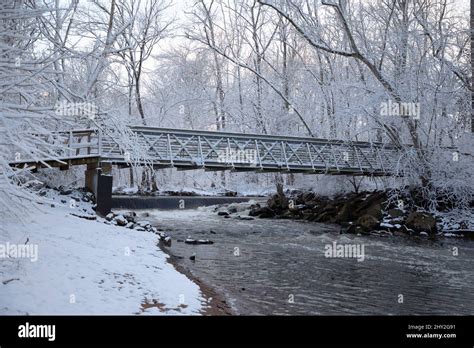 Snow covered bridge over river in the woods Stock Photo - Alamy