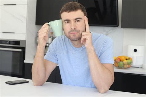 Sleepy Looking Man Holding Coffee Cup In The Kitchen Stock Image