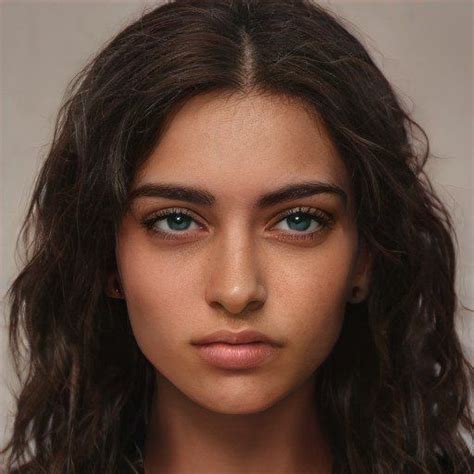 A Close Up Of A Woman With Dark Hair And Brown Eyes Wearing A White Shirt